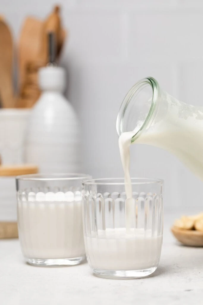 cashew milk being poured into glass