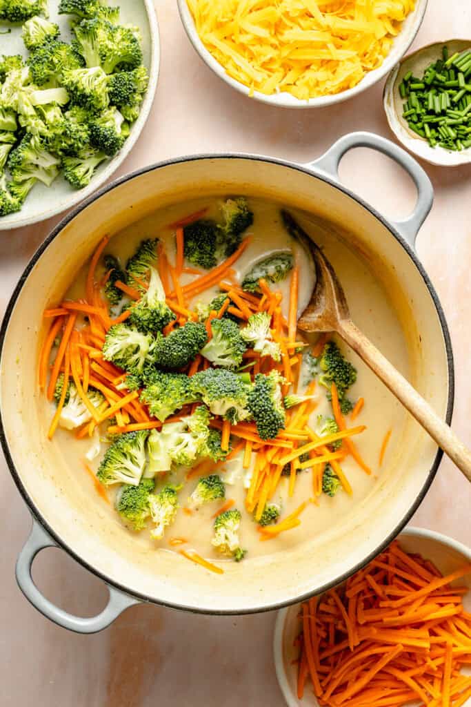 broccoli and carrots being stirred into soup