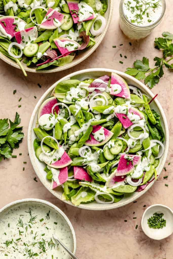ranch dressing poured over greens and radishes