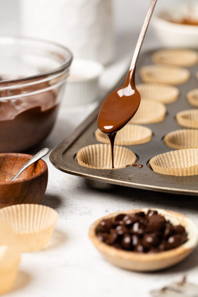 chocolate on spoon pouring into muffin cup