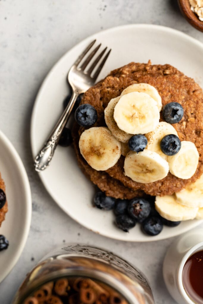 banana oatmeal pancakes on plate topped with fruit