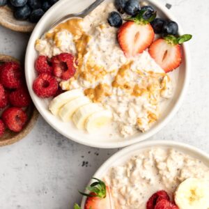 peanut butter overnight oats in two bowls with fresh fruit