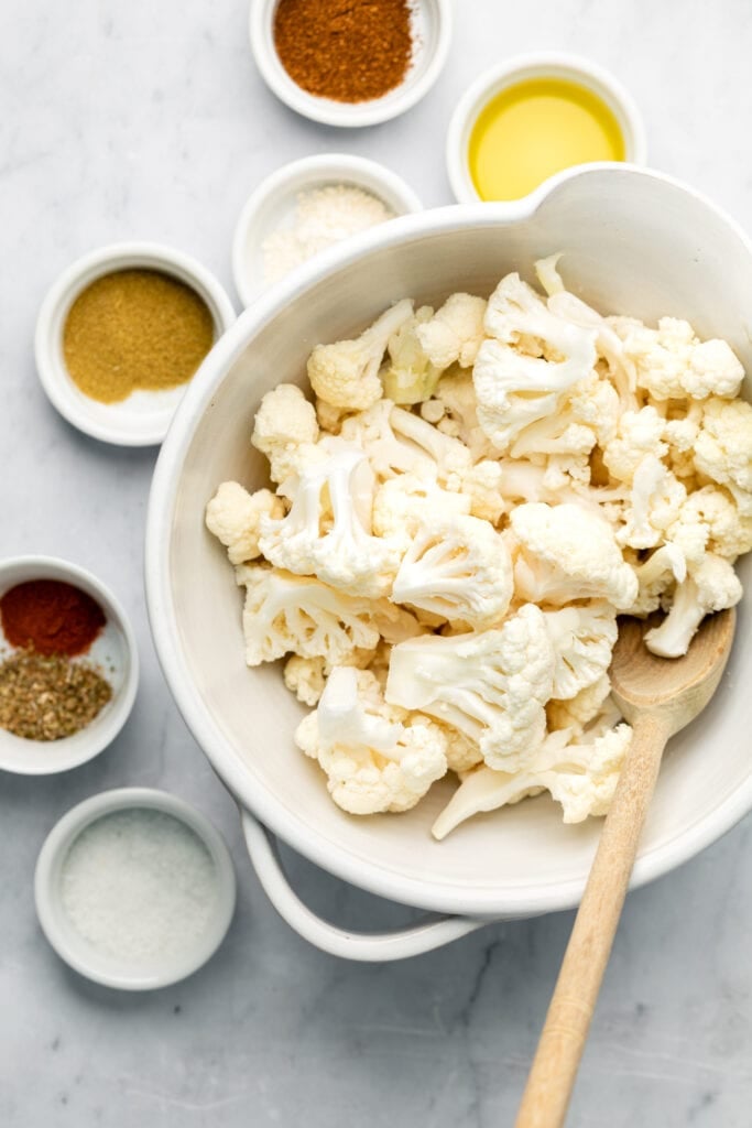 cauliflower in bowl with spices around it
