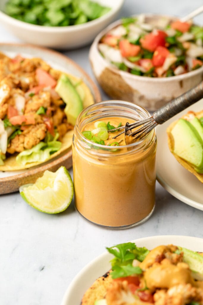 tahini sauce in small jar with whisk