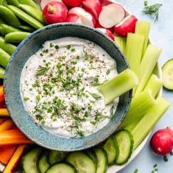 ranch dip in bowl with celery and plate of veggies
