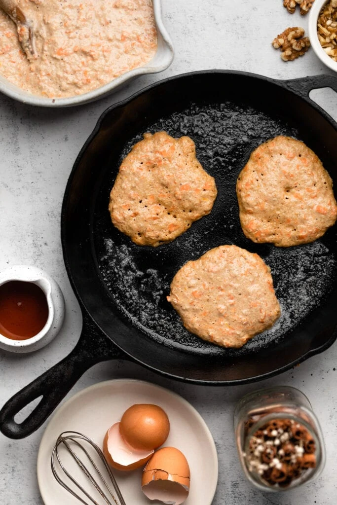 pancakes frying in cast iron skillet