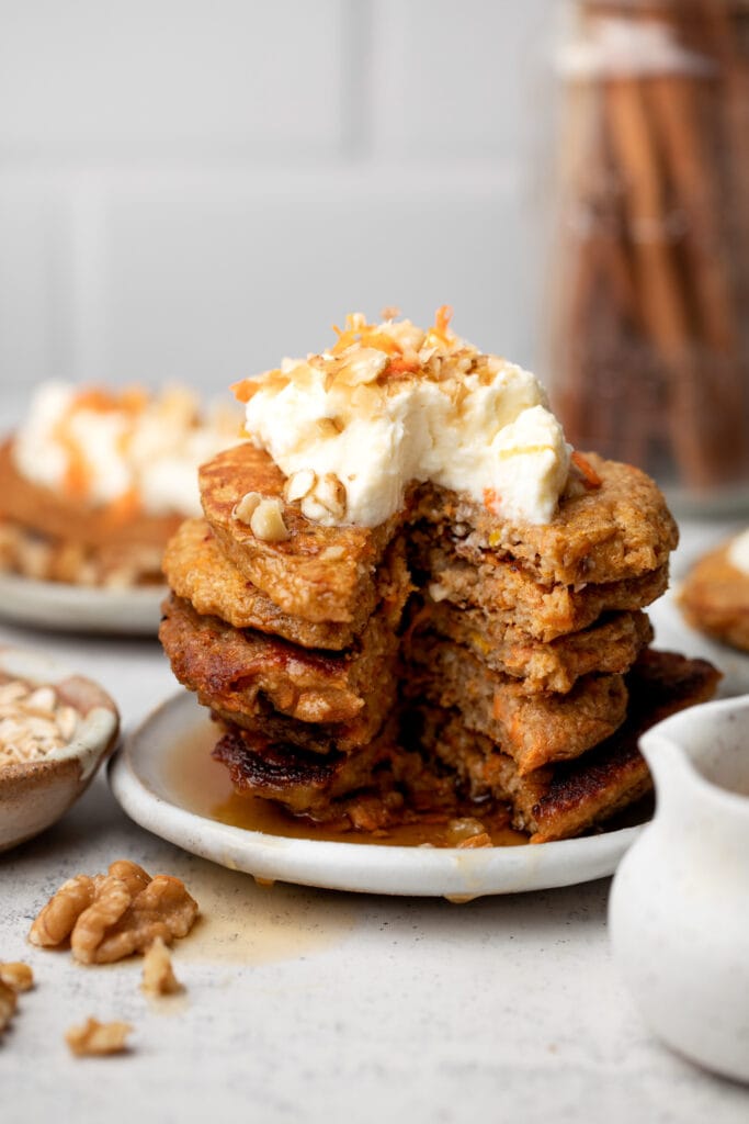 stack of pancakes topped with whipped cream