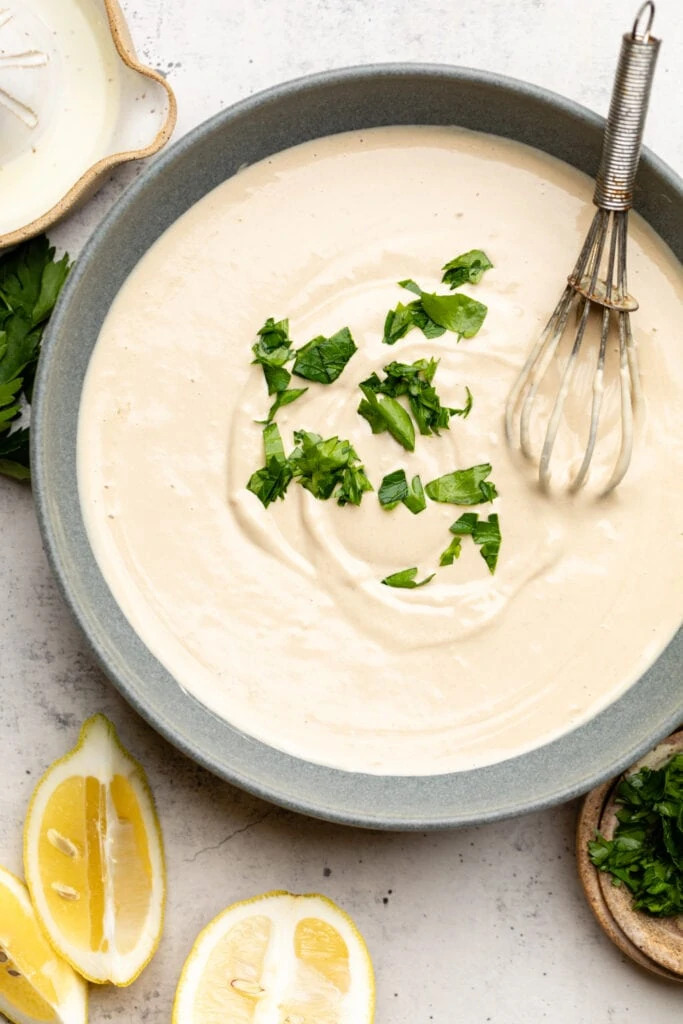 tahini sauce in bowl with whisk