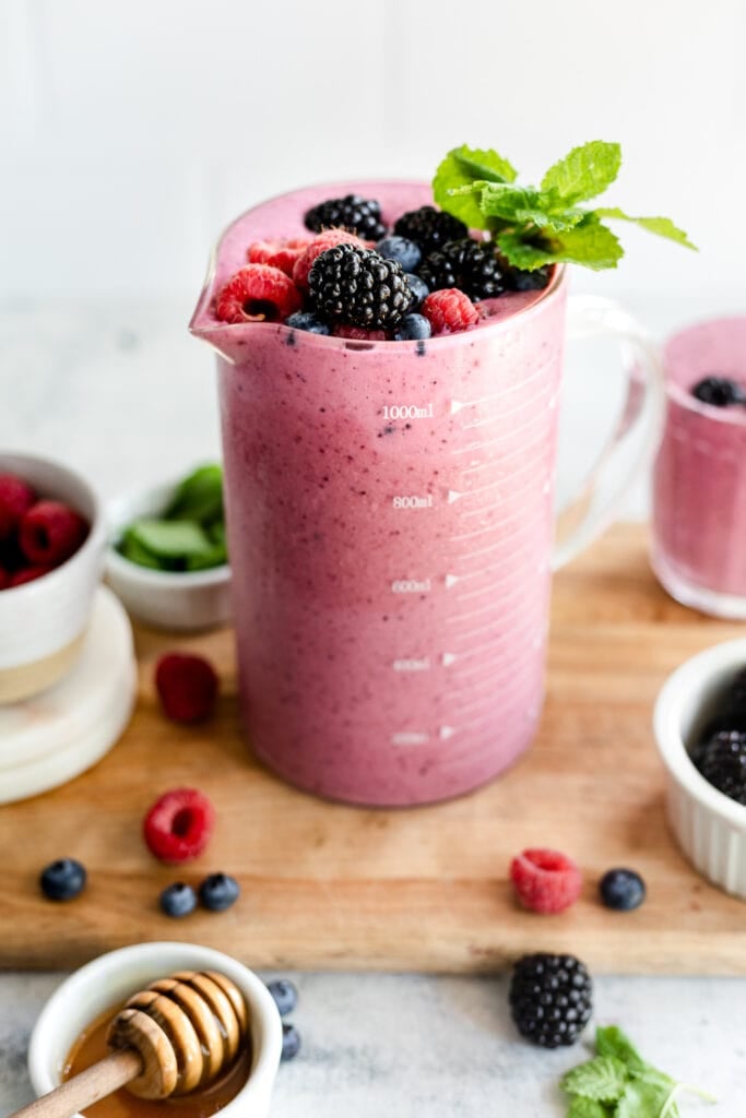 berry smoothie in jar topped with fruit