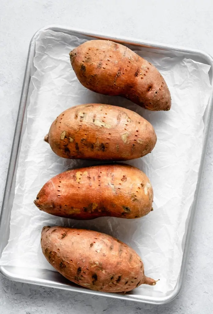 sweet potatoes on sheet pan with parchment paper