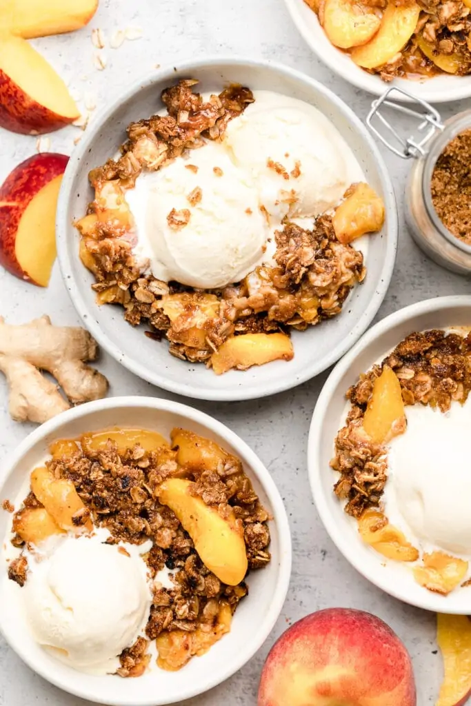 peach crisp served in bowls with ice cream