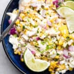 street corn salad in a bowl with lime