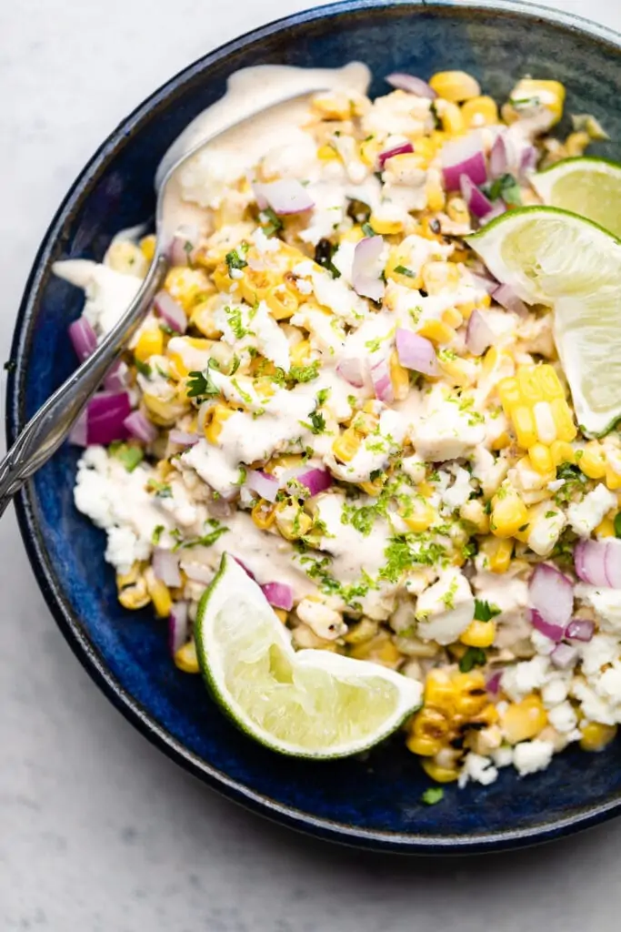 street corn salad in a bowl with lime