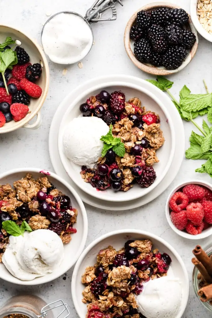 triple berry crisp with ice cream in a bowl