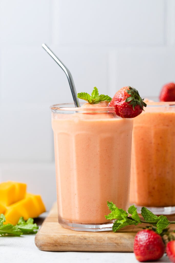 strawberry mango smoothie in a cup with a straw