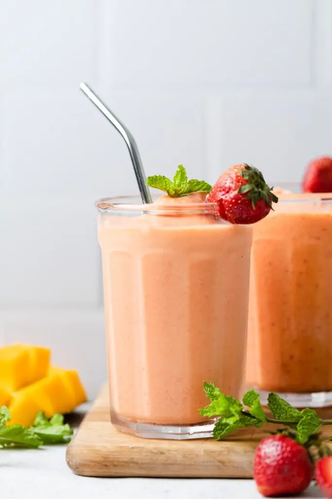 strawberry mango smoothie in a cup with a straw