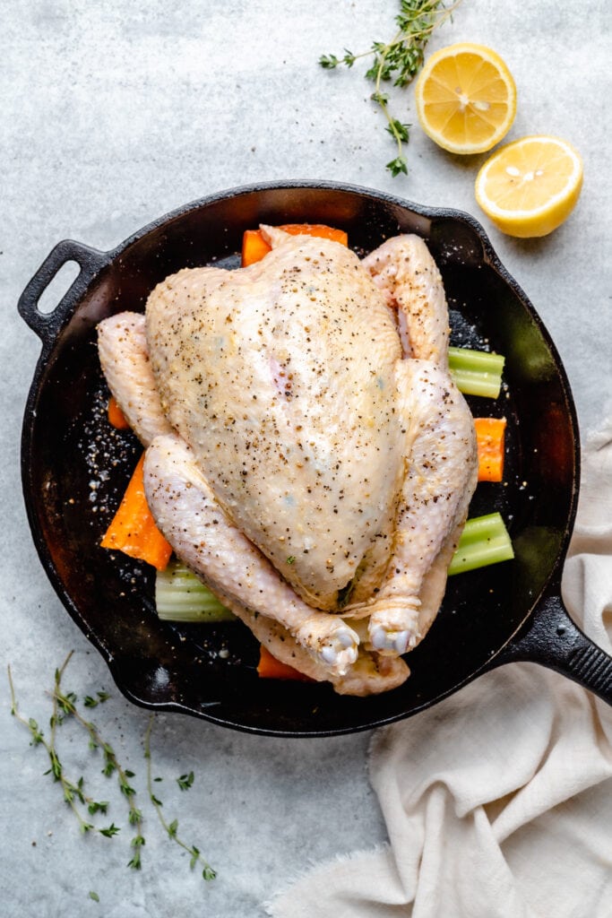 whole chicken on vegetables in skillet