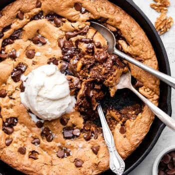 oatmeal chocolate chip skillet cookie with ice cream and spoons