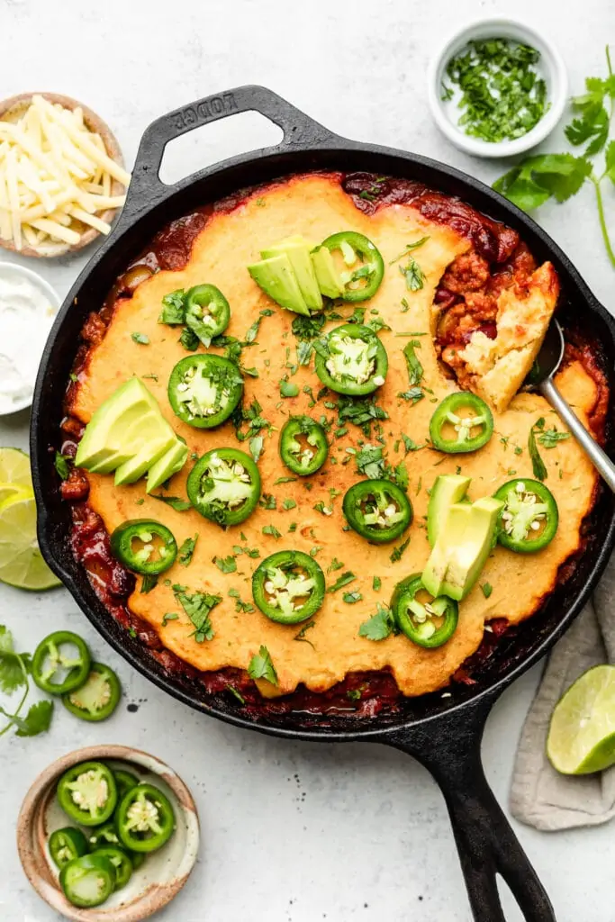 chili pie in skillet with toppings