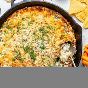 spinach artichoke dip in skillet with spoons