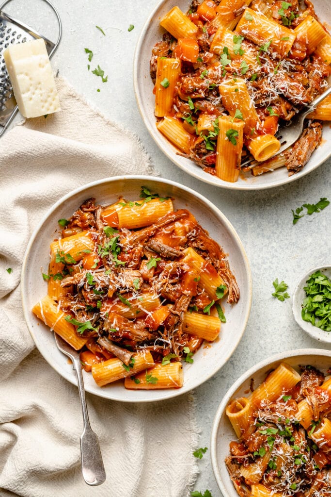 short rib ragu over pasta in bowls