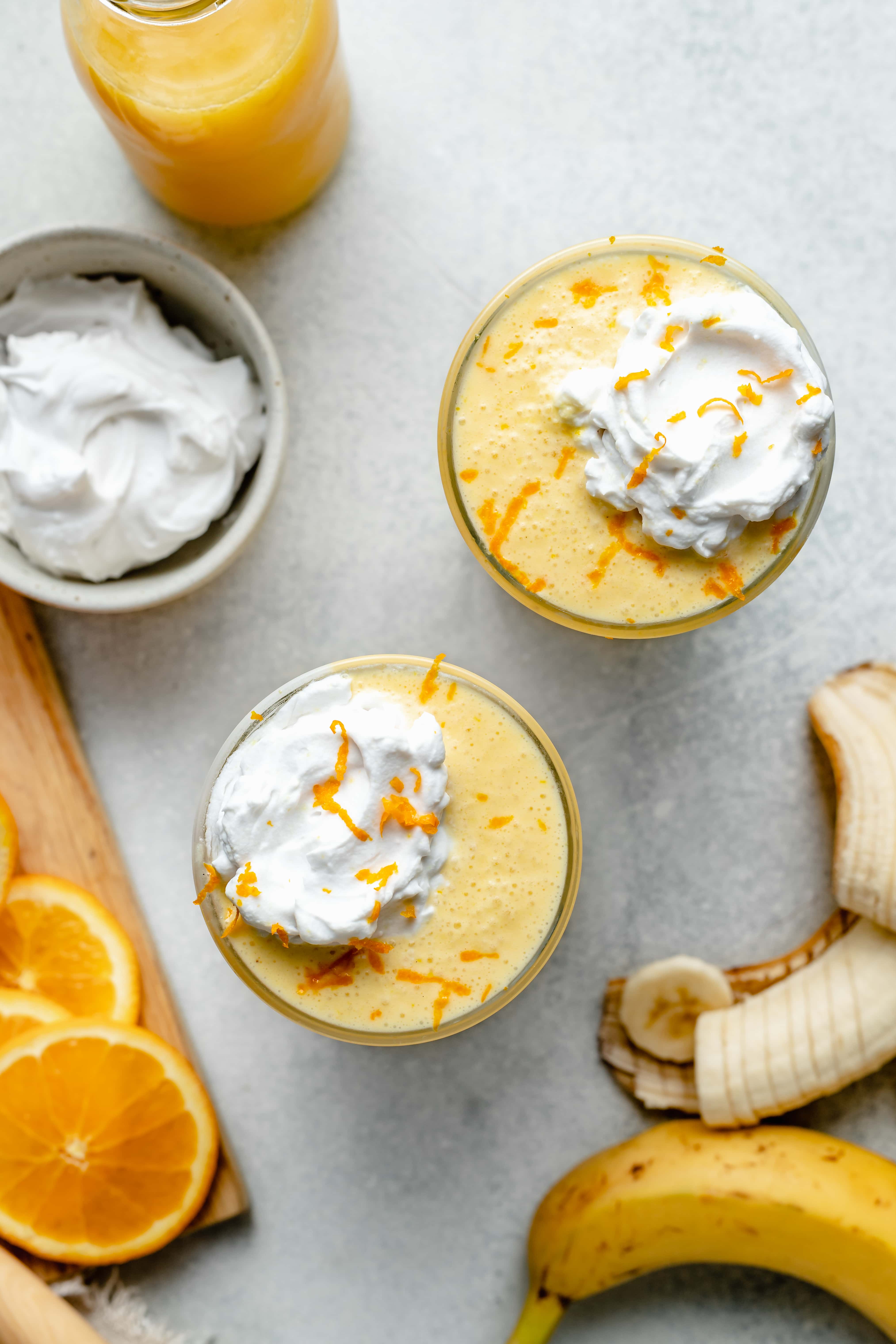 orange creamsicle smoothie topped with coconut cream and orange zest