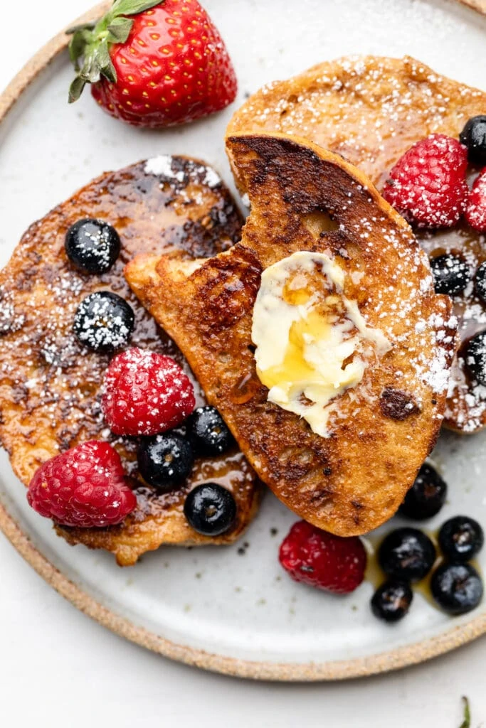 French toast on plate with butter and berries