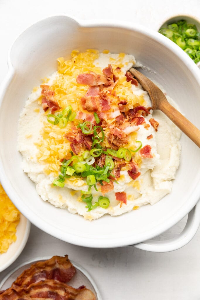 mashed cauliflower, cheese, bacon, and green onion in bowl