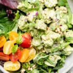 pesto chicken salad over greens with tomatoes