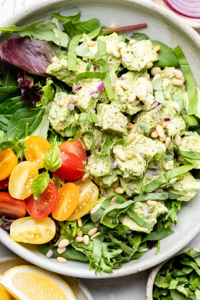 pesto chicken salad over greens with tomatoes