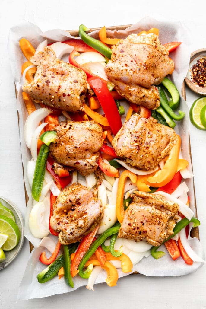 raw chicken and peppers on sheet pan