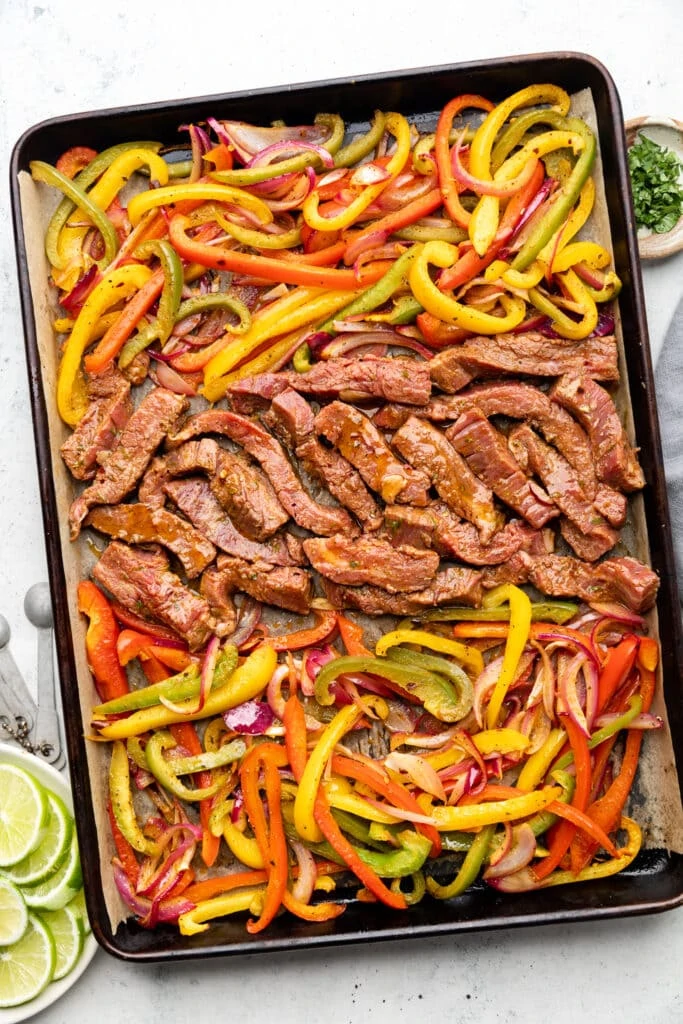 uncooked steak and veggies on sheet pan