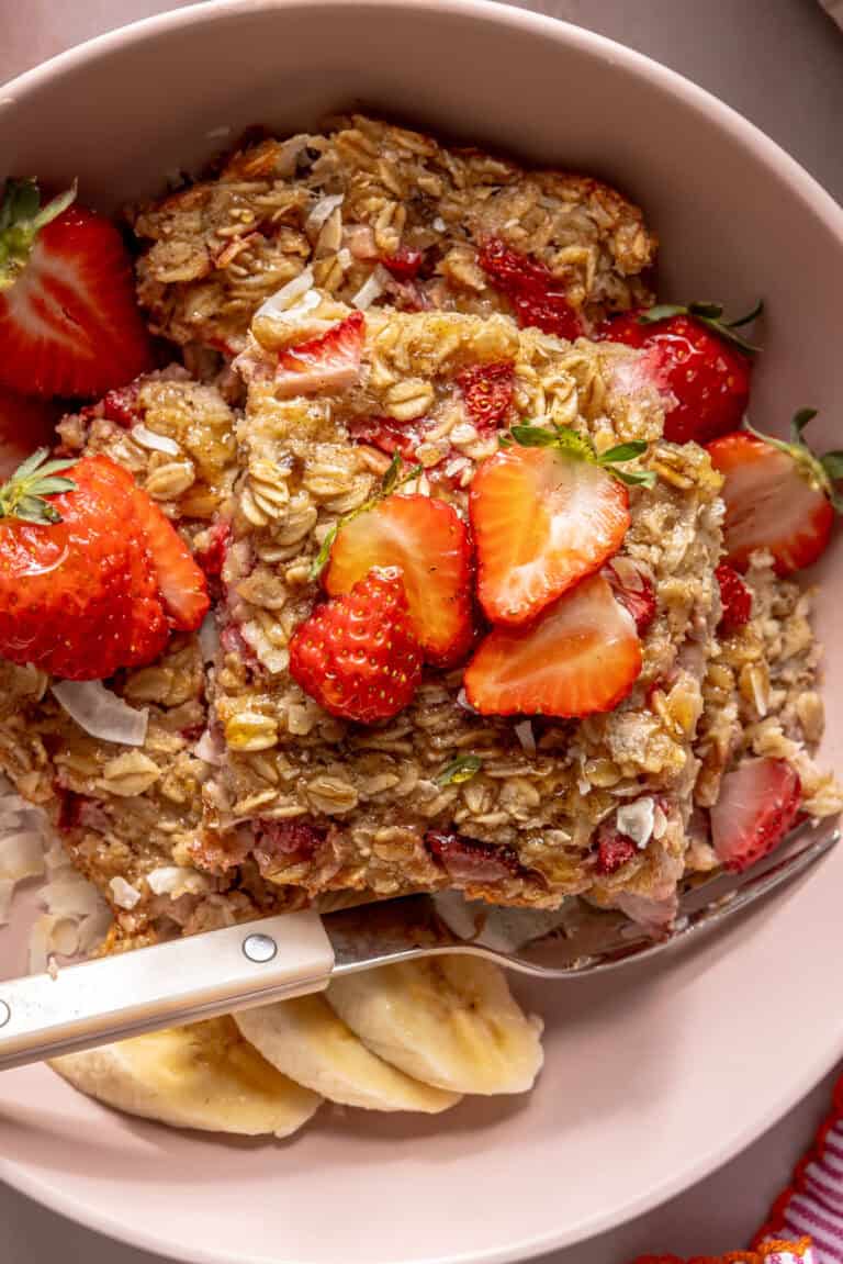 strawberry banana baked oatmeal in bowl with fork and banana slices