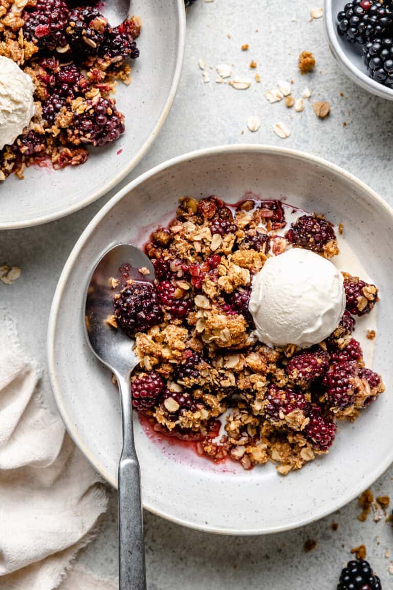 blackberry crisp in bowl with ice cream