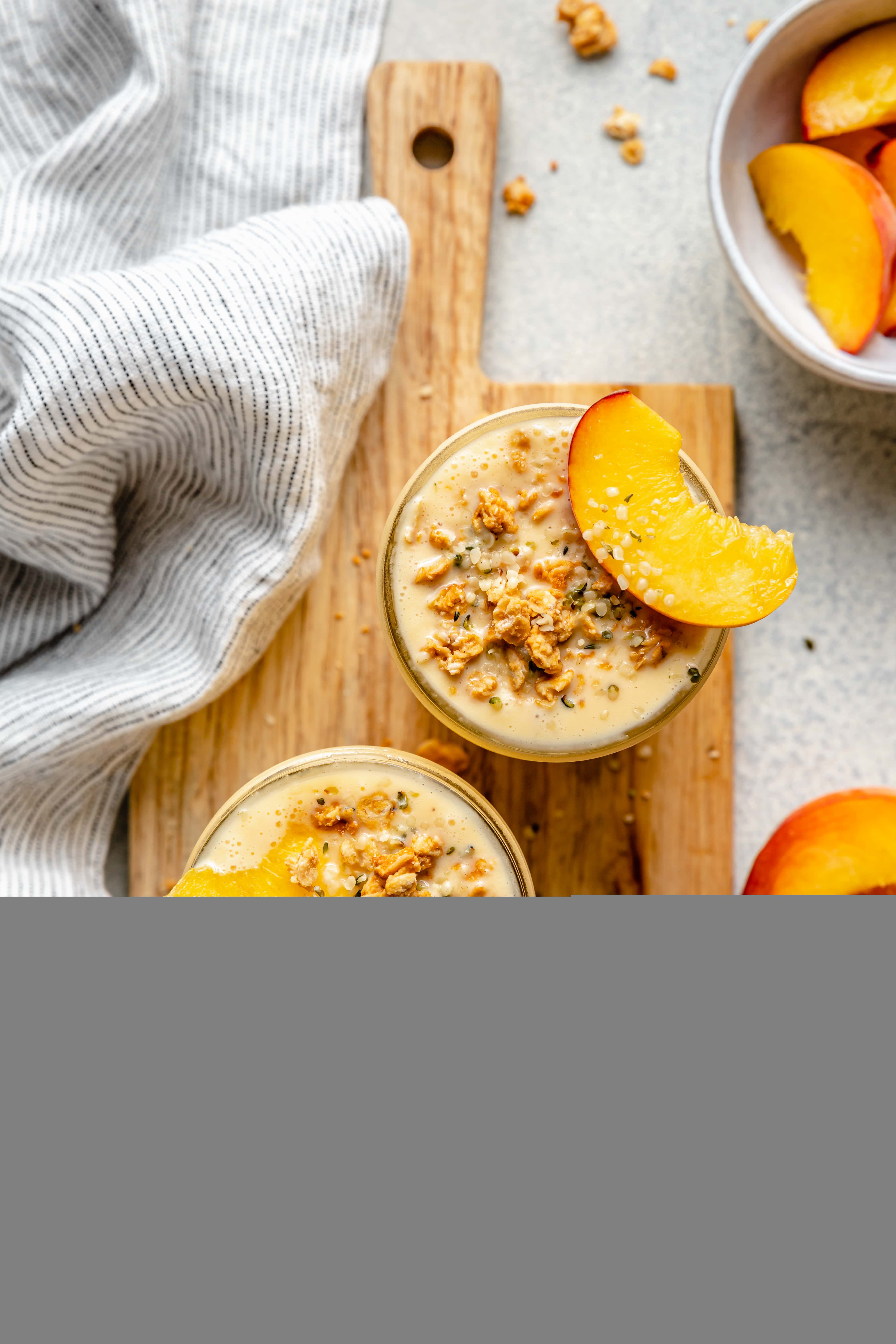 creamy peach smoothie topped with granola and peach