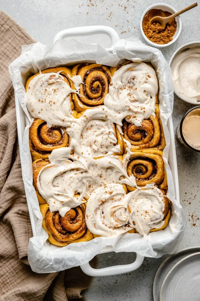 pumpkin cinnamon roll in pan with icing