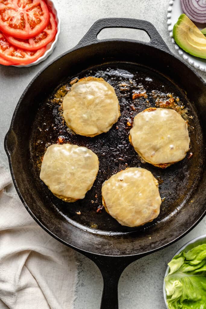turkey burger patties with cheese in cast iron skillet