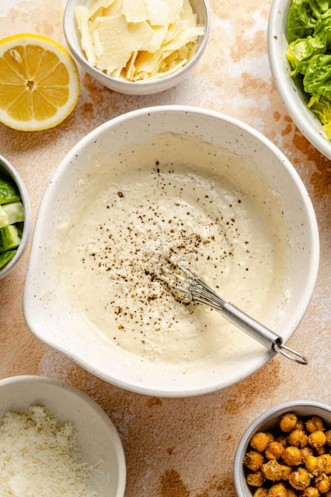 caesar dressing in bowl with whisk