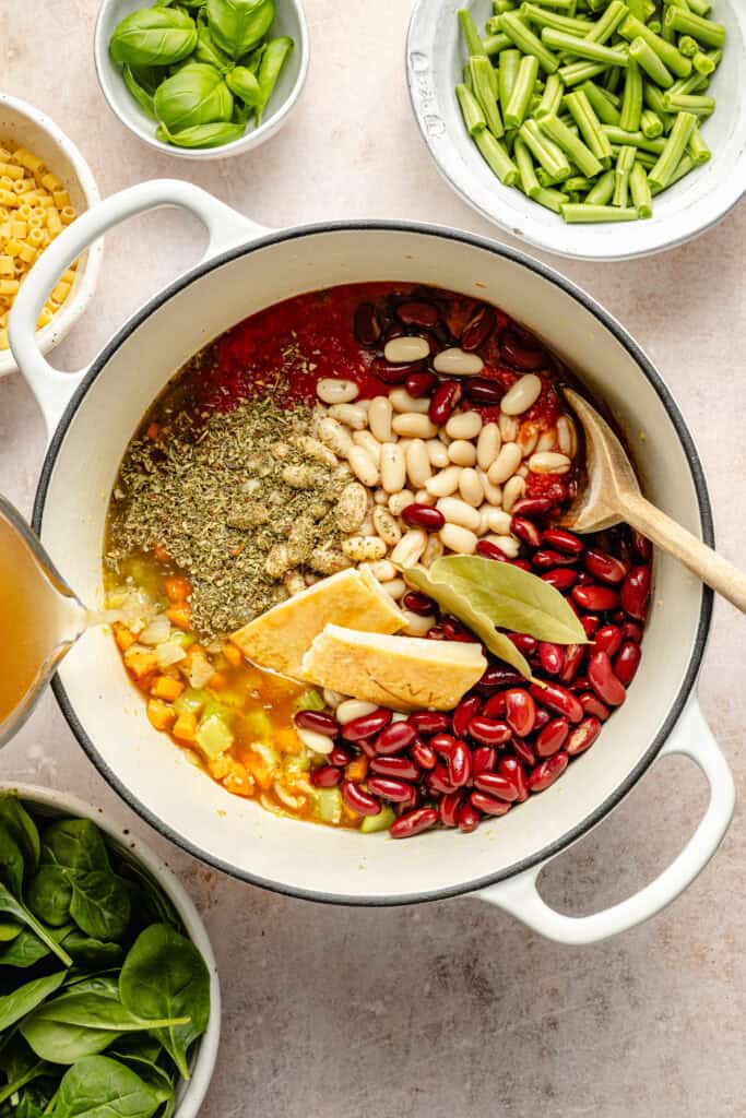 soup ingredients in pot with wooden spoon