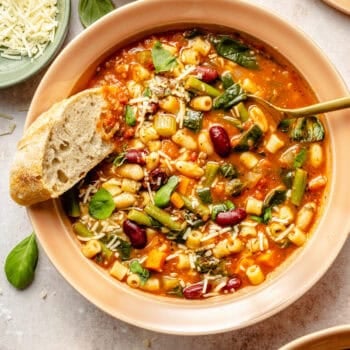 minestrone soup in bowl with spoon and crusty bread