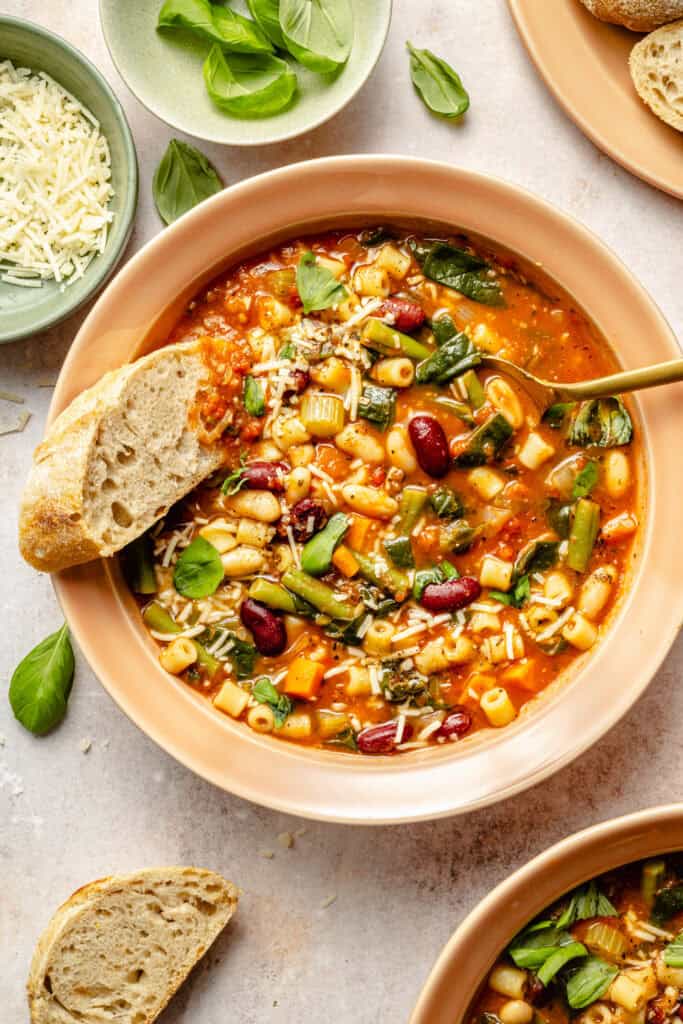 minestrone soup in bowl with spoon and crusty bread