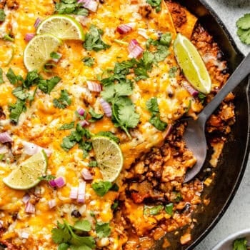 enchilada casserole in skillet with spoon