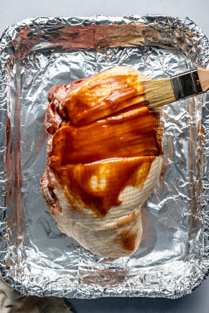 glaze being brushed on ham 