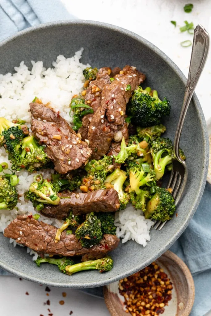 beef and broccoli over rice in bowl