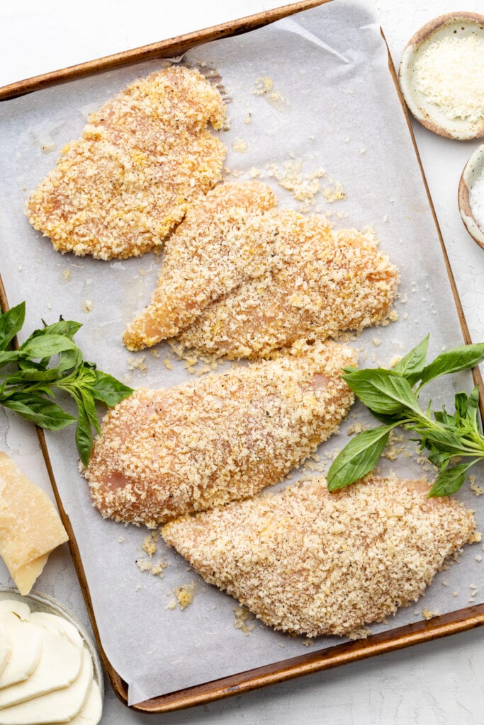coated chicken cutlets on sheet pan