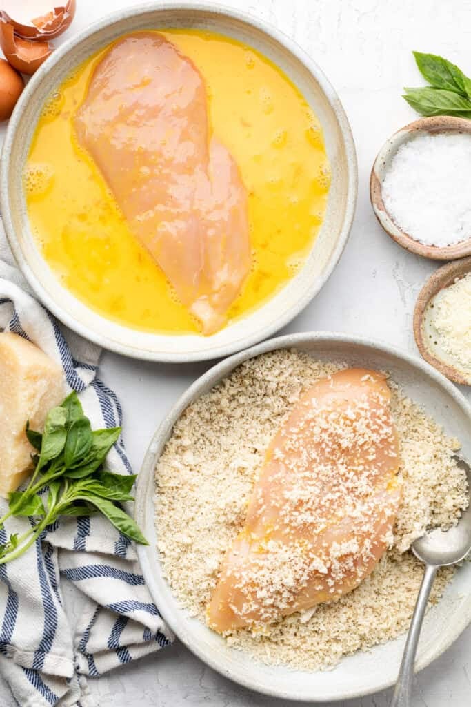 chicken being breaded in the egg mixture and breadcrumb mixture