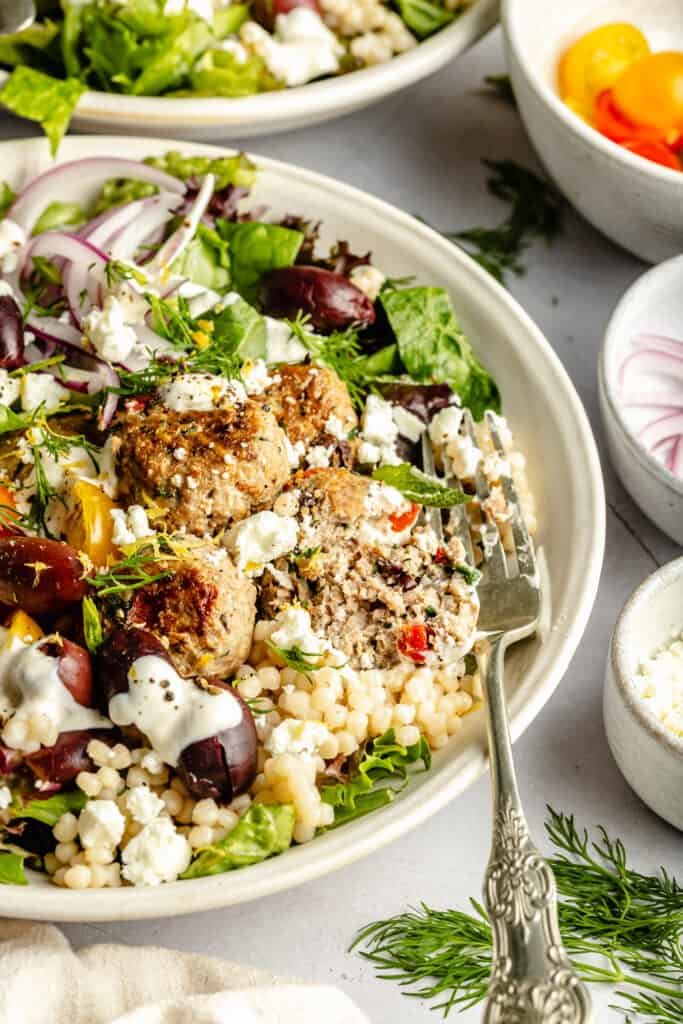 turkey meatballs in bowl over couscous and salad