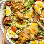 Cobb salad in serving dish with wooden spoon