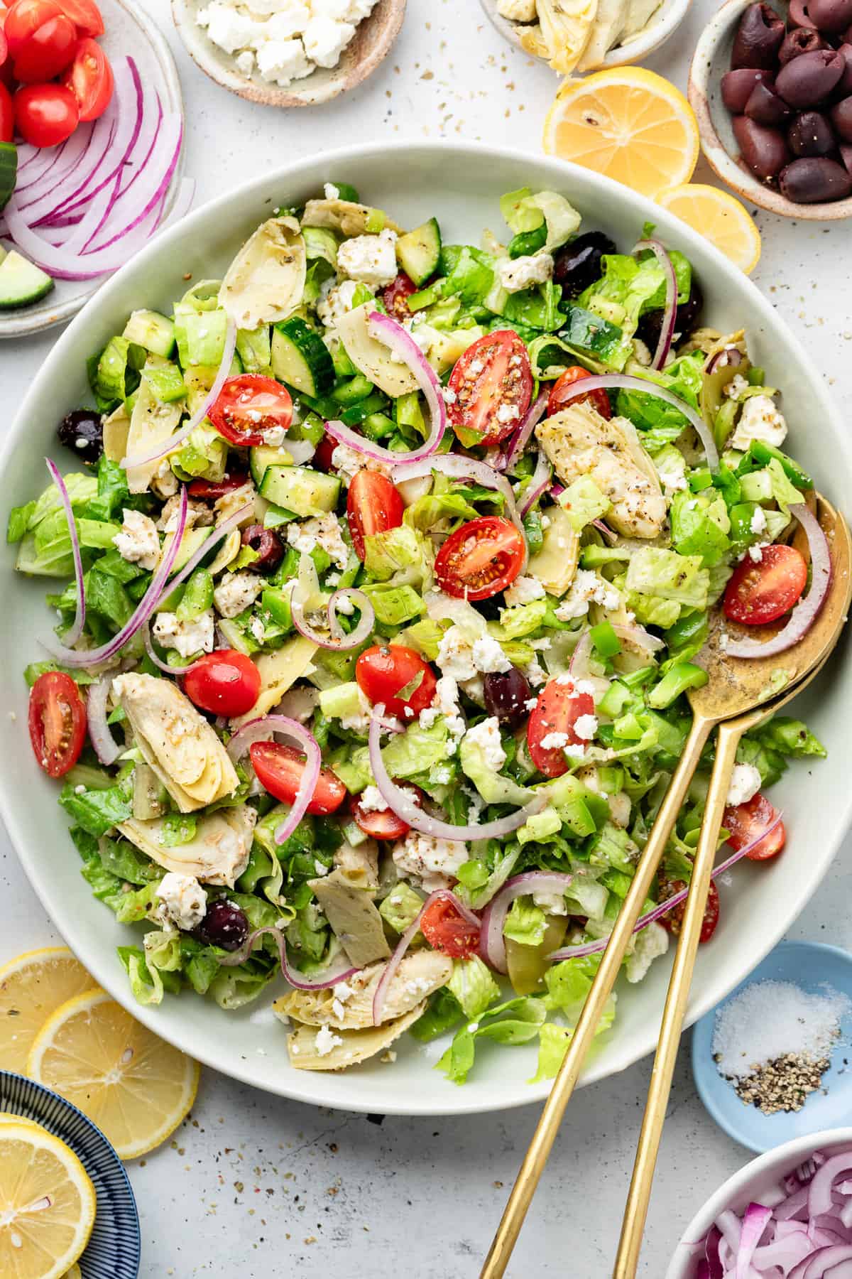 greek salad in serving bowl with tongs