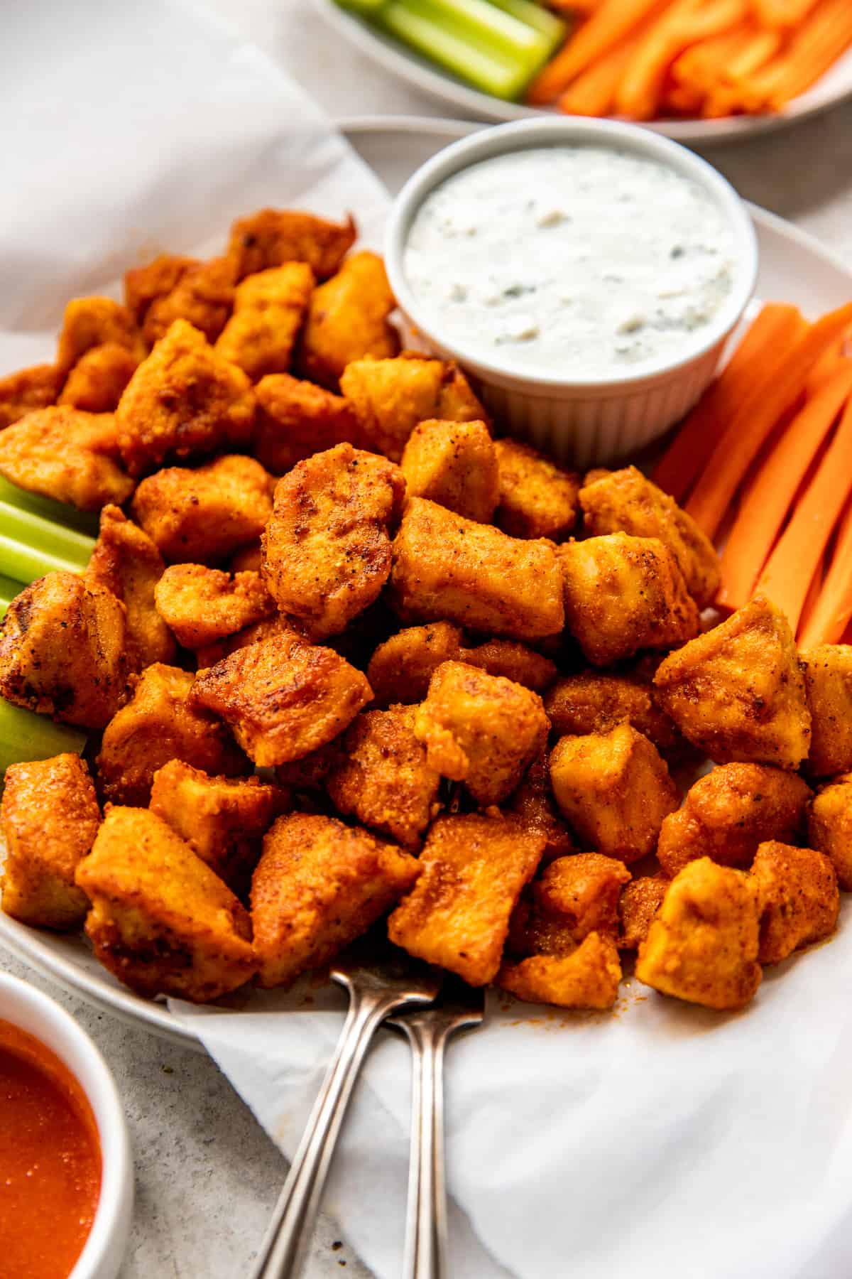 buffalo chicken bites on platter with veggies and dip